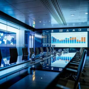 a sleek, modern conference room filled with high-tech screens displaying colorful graphs and metrics, emphasizing the strategic discussions on optimizing ppc performance for a digital marketing campaign.